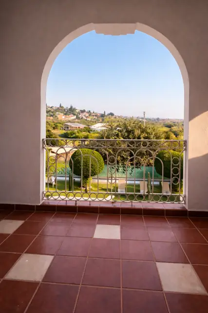 Balcón con arco y vista a la sierra